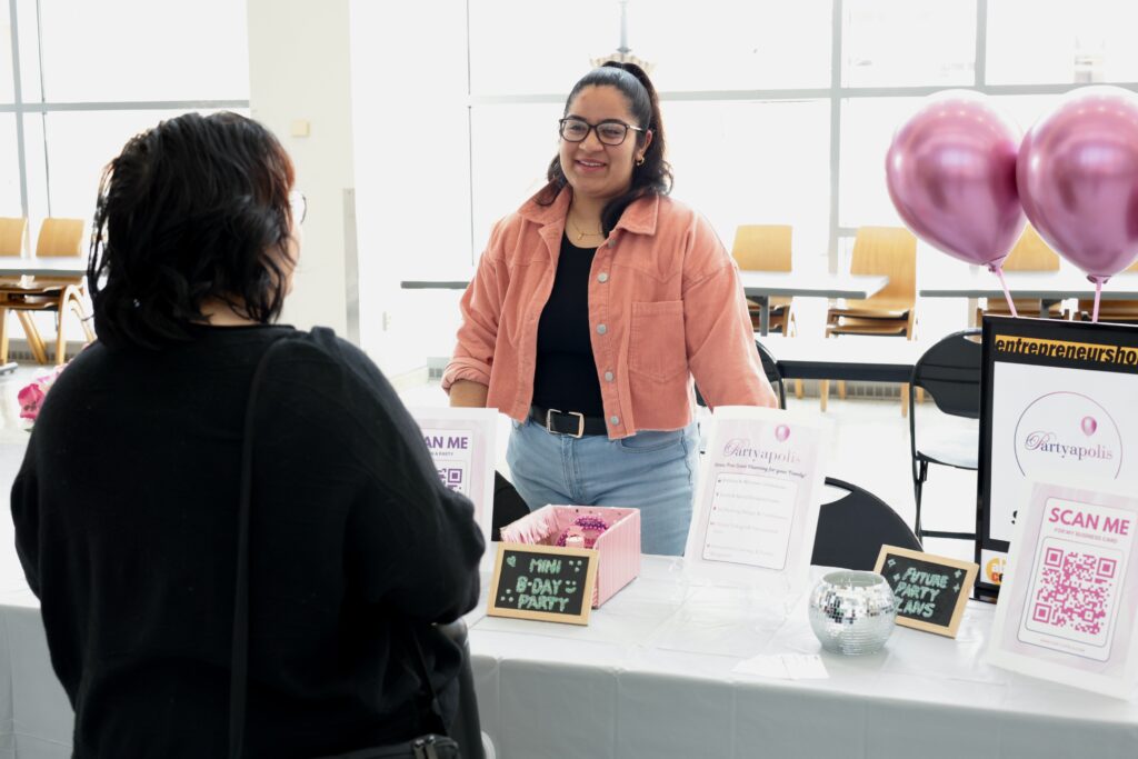 Student entrepreneur talking to another student about her business